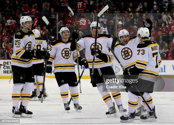 Charlie McAvoy of the Boston Bruins is congratulated by Frank Vatrano and the rest of his teammates off the bench after he scored to win the game in...