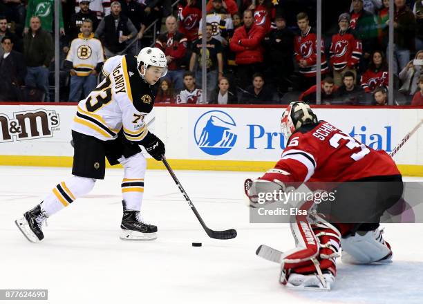 Charlie McAvoy of the Boston Bruins scores the game winning goal in an overtime shootout against Cory Schneider of the New Jersey Devils on November...