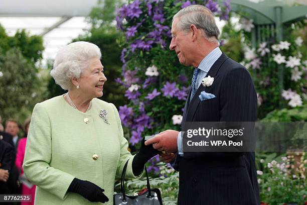 Queen Elizabeth II presents Prince Charles, Prince of Wales with the Royal Horticultural Society's Victoria Medal of Honour during a visit to the...