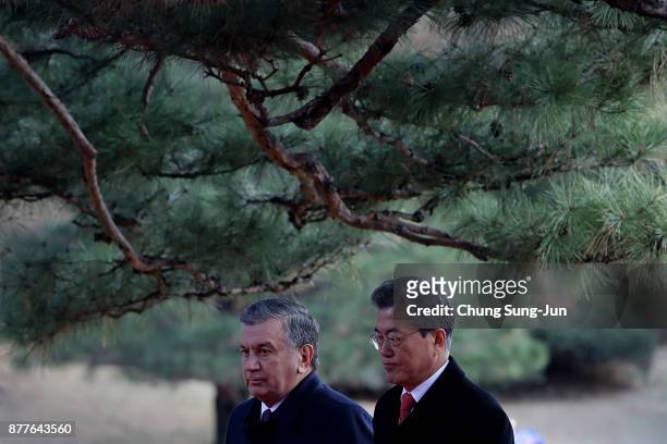 South Korean President Moon Jae-In and Uzbekistan President Shavkat Mirziyoyev walk during a welcoming ceremony at the presidential Blue House on...
