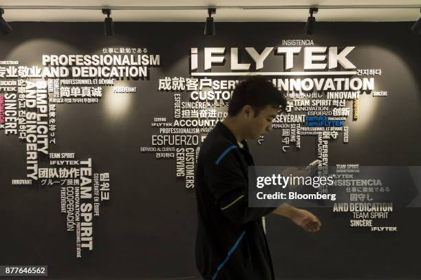 An employee walks past a wall display inside Iflytek Co.'s regional headquarters in Guangzhou, China, on Tuesday, Oct. 31, 2017. Iflytek, which...