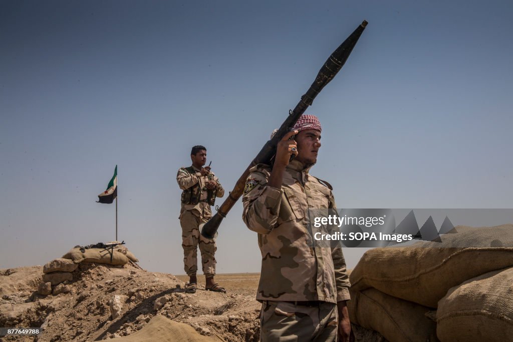 Soldiers of Quwat al Nukhba overlooks an ISIS village and...