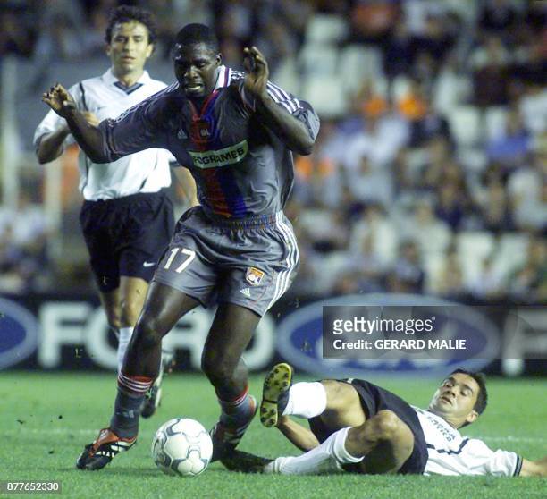 Le Lyonnais Marc-Vivien Foé est aux prises avec deux joueurs de Valence, Kily Gonzales et Amedeo Carboni, le 27 septembre 2000 au stade Mestalla de...