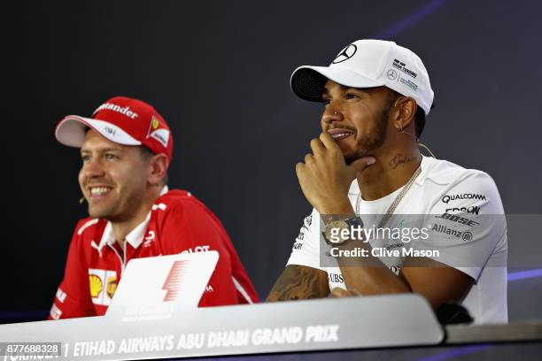 Lewis Hamilton of Great Britain and Mercedes GP and Sebastian Vettel of Germany and Ferrari look on in the Drivers Press Conference during previews...