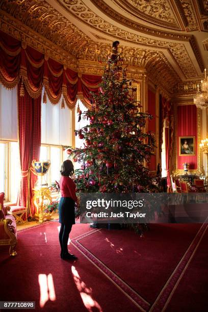 An employee poses with a 15ft Christmas tree in the Crimson Drawing Room which has been decorated for the Christmas period on November 23, 2017 in...