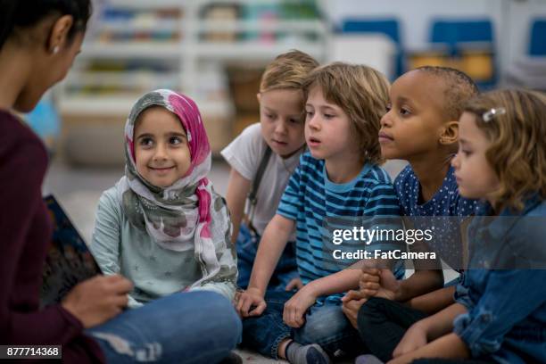 lezing aan de klasse - small child sitting on floor stockfoto's en -beelden