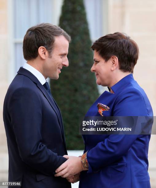 French President Emmanuel Macron welcomes Polish Prime Minister Beata Szydlo before a meeting at the Elysee Palace in Paris on November 23, 2017. /...