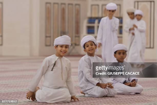 Children attend a group prayer on October 31, 2017 at Muscat's Sayyida Mazoon mosque in the Gulf sultanate of Oman. - Oman -- home to Sunnis, Shiites...