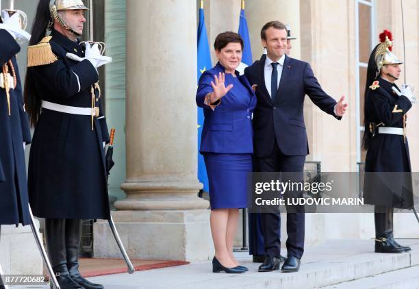 French President Emmanuel Macron welcomes Polish Prime Minister Beata Szydlo before a meeting at the Elysee Palace in Paris on November 23, 2017. /...