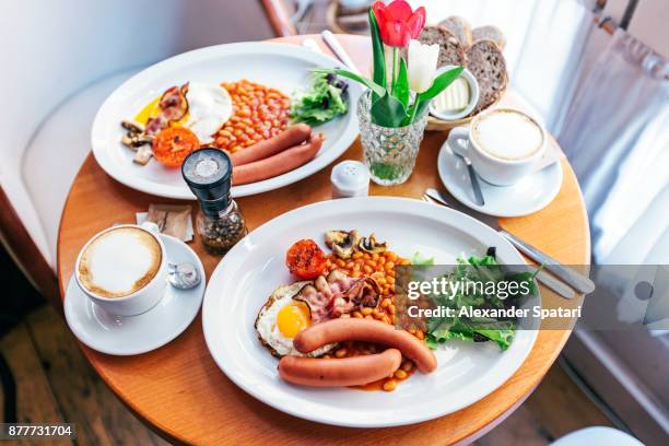 english breakfast with eggs, beans, bacon, sausages, mushrooms and tomatoes - cosy pub stock pictures, royalty-free photos & images