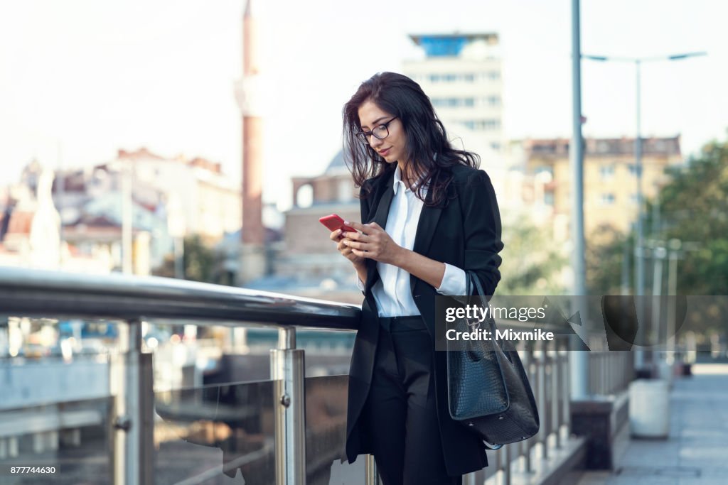 Businesswoman texting on her mobile phone