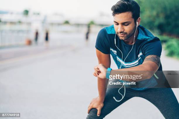 athlete looking at his smart watch - running man heartbeat stock pictures, royalty-free photos & images