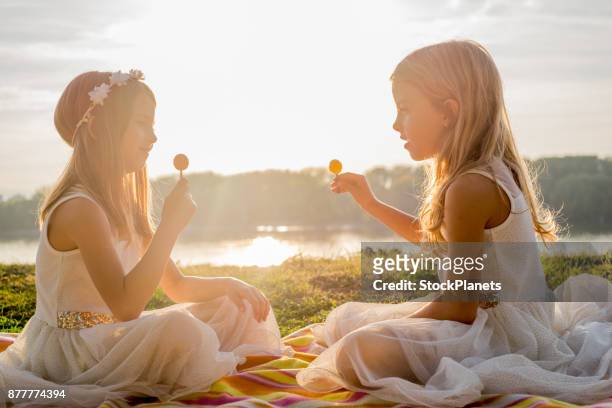 sisters and lollipops on sunset - girl lollipops stock pictures, royalty-free photos & images