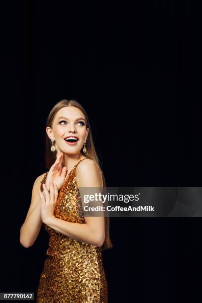 beautiful woman wearing golden dress - gold dress stock pictures, royalty-free photos & images