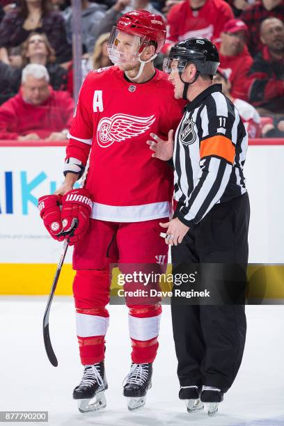 Justin Abdelkader of the Detroit Red Wings talks with referee Kelly Sutherland on a play stoppage against the Colorado Avalanche during an NHL game...