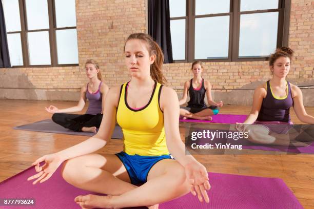 gruppe von vier jungen frauen im studio yoga-übung-gesundheits-zentrum - yin yoga stock-fotos und bilder