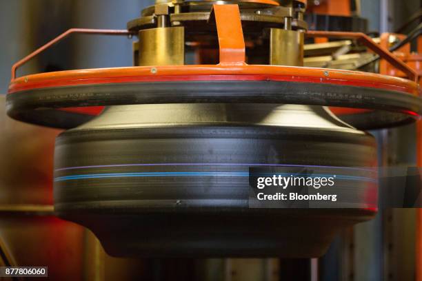 Machine moves a 'green' automobile tire before vulcanization at the Continental AG tire plant in Kaluga, Russia, on Wednesday, Nov. 22, 2017. The...