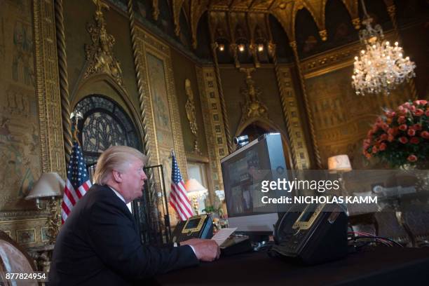 President Donald Trump thanks members of the US military via video teleconference on Thanksgiving day, November 23, 2017 from his residence in...