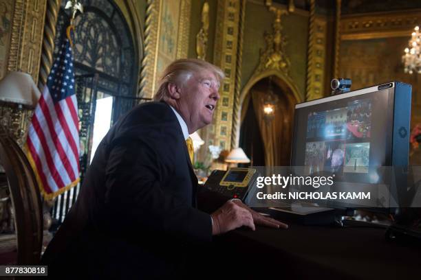 President Donald Trump thanks members of the US military via video teleconference on Thanksgiving day, November 23, 2017 from his residence in...