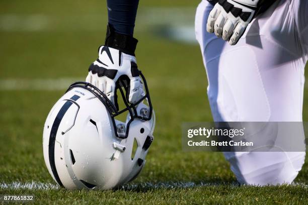 Detail view of a Penn State Nittany Lions football helmet held by a kneeling player before the game against the Nebraska Cornhuskers on November 18,...