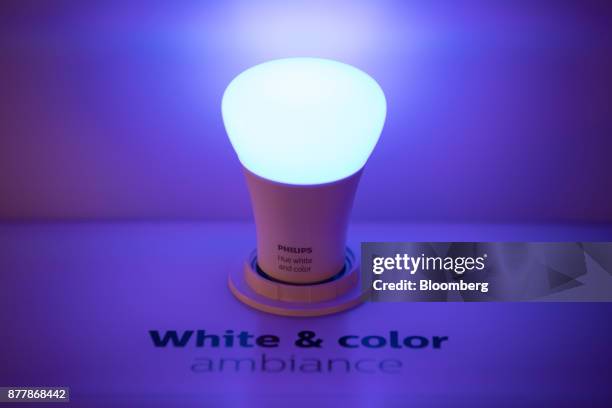 Philips Hue white and color ambiance lighting bulb sits illuminated at the Philips Lighting NV experience center in Eindhoven, Netherlands, on...