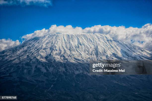 clouds around kilimanjaro - kilimanjaro stockfoto's en -beelden