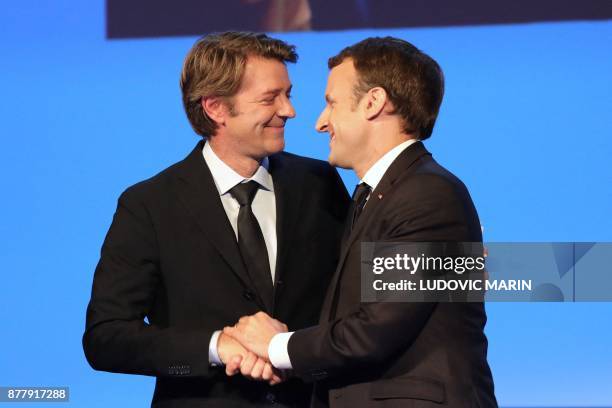 Mayor of Troyes and President of the Association of Mayors of France Francois Baroin and French President Emmanuel Macron shake hands during the...