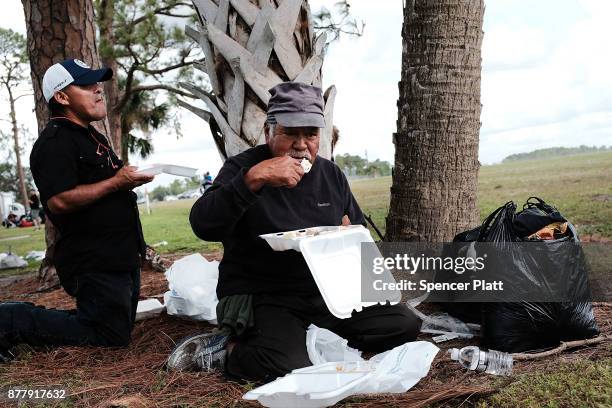 Men eat at the annual Thanksgiving in the Park gathering where residents of the farm worker community of Immokalee are provided with a free...