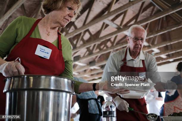 Volunteers prepare food at the annual Thanksgiving in the Park gathering where residents of the farm worker community of Immokalee are provided with...