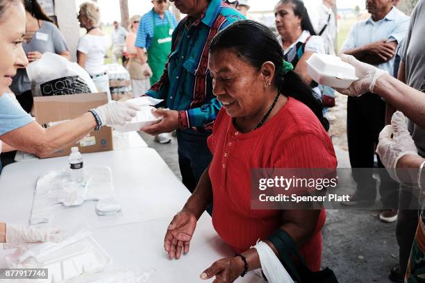 People receive food at he annual Thanksgiving in the Park gathering where residents of the farm worker community of Immokalee are provided with a...