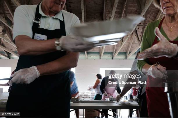 Volunteers prepare food at the annual Thanksgiving in the Park gathering where residents of the farm worker community of Immokalee are provided with...