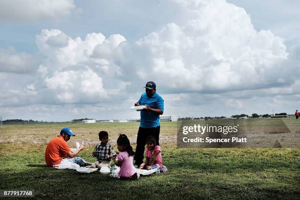 Family eats at the annual Thanksgiving in the Park gathering where residents of the farm worker community of Immokalee are provided with a free...