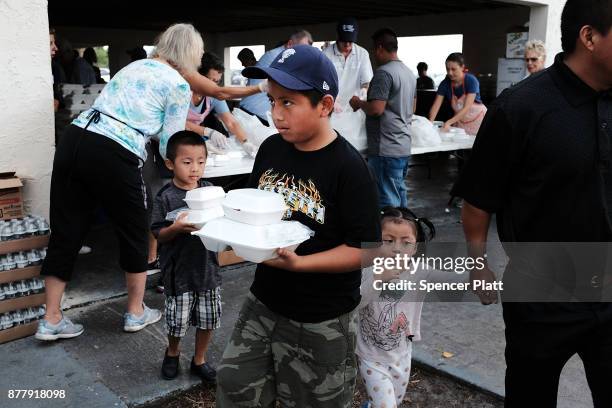 People receive food at he annual Thanksgiving in the Park gathering where residents of the farm worker community of Immokalee are provided with a...