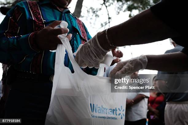 People receive food at he annual Thanksgiving in the Park gathering where residents of the farm worker community of Immokalee are provided with a...