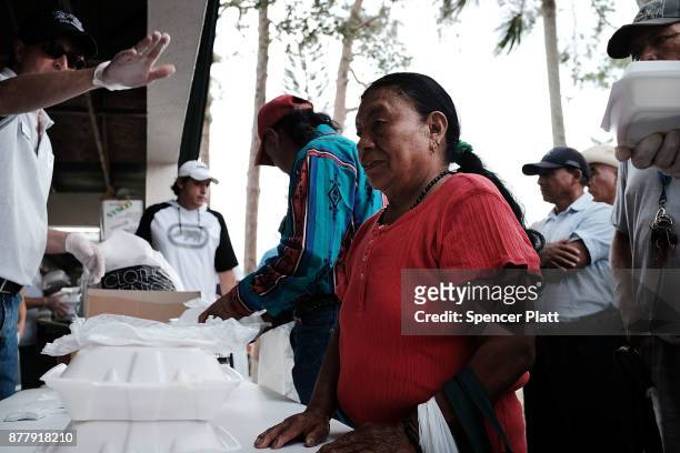 People receive food at he annual Thanksgiving in the Park gathering where residents of the farm worker community of Immokalee are provided with a...