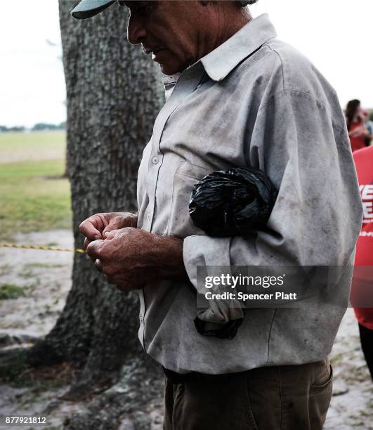 Man waits for food to be served at the annual Thanksgiving in the Park gathering where residents of the farm worker community of Immokalee are...