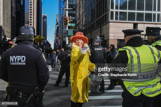 Performer throws confetti near law enforcement on 6th Ave. Amid increased security during the annual Macy's Thanksgiving Day parade on November 23,...
