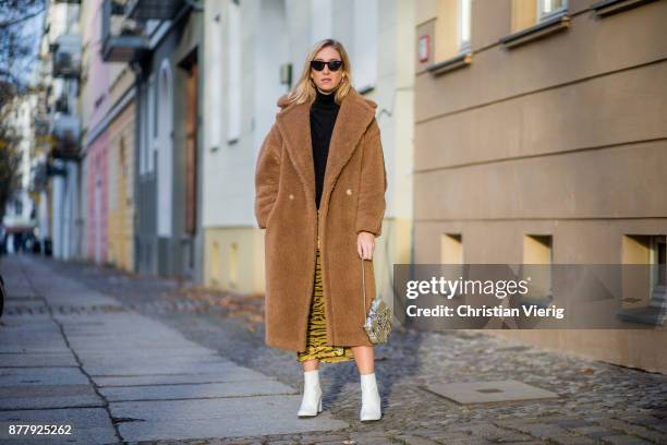 Sonia Lyson wearing a brown teddy coat Max Mara, Gigi Hadid x Vogue Eyewear sunglasses, white lack boots Edited, yellow skirt with animal print...