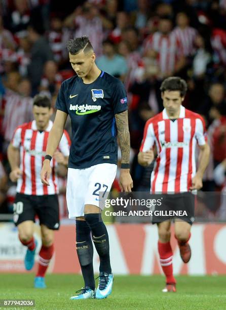 Hertha BSC Berlin's German defender Marvin Plattenhardt walks as Athletic Bilbao players celebrate their second goal during the Europa League...