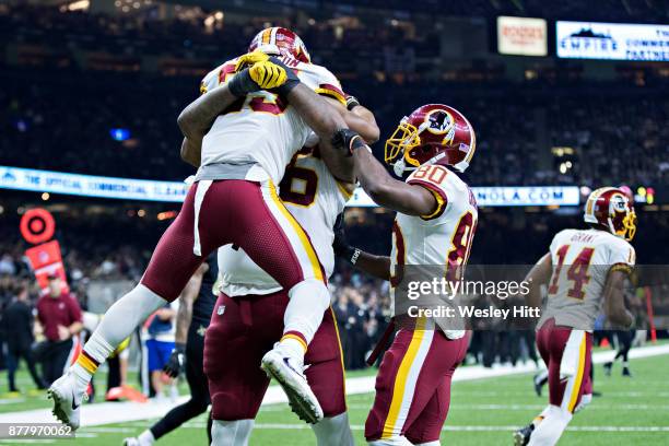 Chris Thompson is lifted in the air by Morgan Moses of the Washington Redskins after scoring a touchdown during a game against the New Orleans Saints...