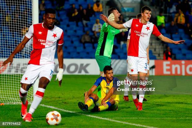 Maccabi's Israeli defender Dor Micha sits on the ground as Slavia's Ivorian defender Simon Deli gathers the ball during the Europa League Group A...