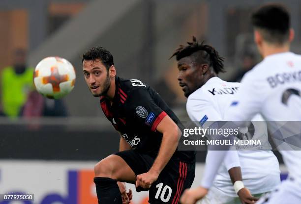 Milan's German midfielder Hakan Calhanoglu vies with Austria Wien's from Ghana defender Abdul Mohamed during the UEFA Europa League group D football...