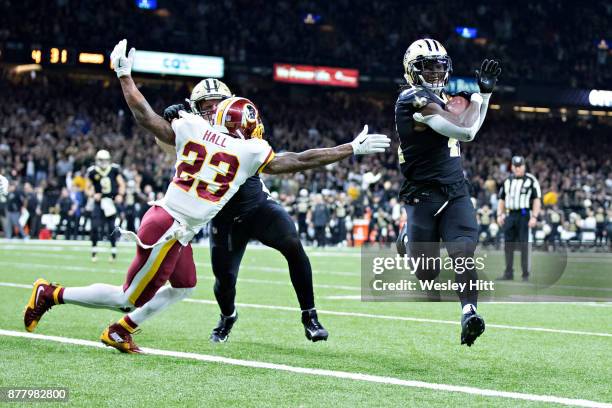 Alvin Kamara of the New Orleans Saints rushes for a touchdown past the outstretched arm of DeAngelo Hall of the Washington Redskins at Mercedes-Benz...