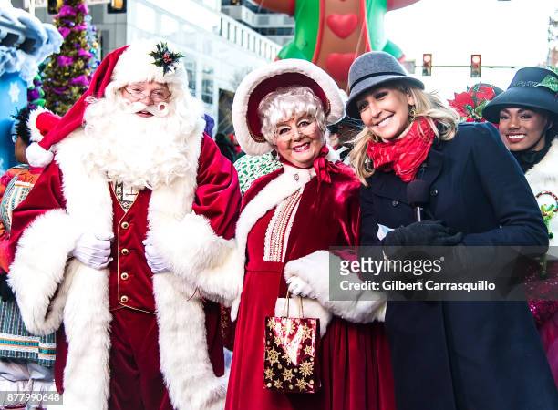 Television personality Lara Spencer poses with Santa Claus and Mrs. Claus during the 98th Annual 6abc/Dunkin' Donuts Thanksgiving Day Parade on...