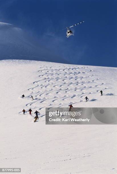 heli-skiers on slope, cariboo mts, british columbia, canada - heli skiing stock pictures, royalty-free photos & images