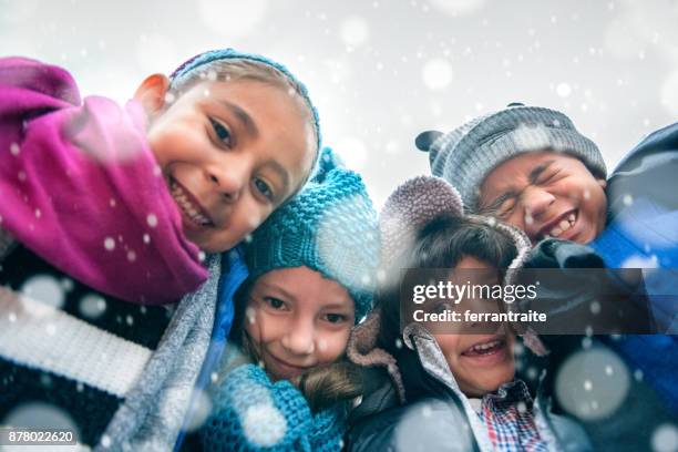 kinder gruppe hug - christmas snow stock-fotos und bilder
