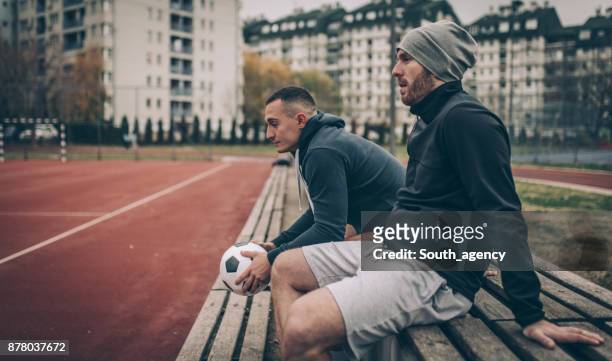 football players sitting on a bench - side lines imagens e fotografias de stock