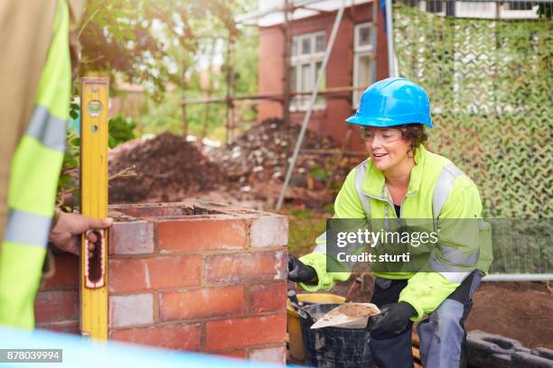 frau maurer mit kollegen - maurer stock-fotos und bilder