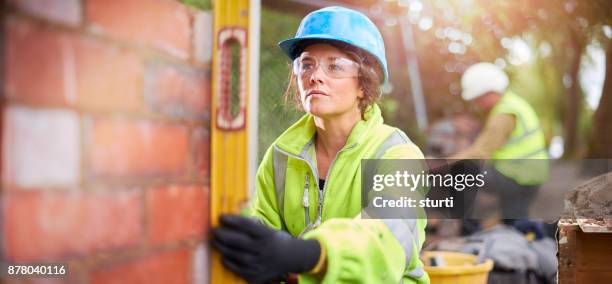 female construction worker on site - female bricklayer stock pictures, royalty-free photos & images