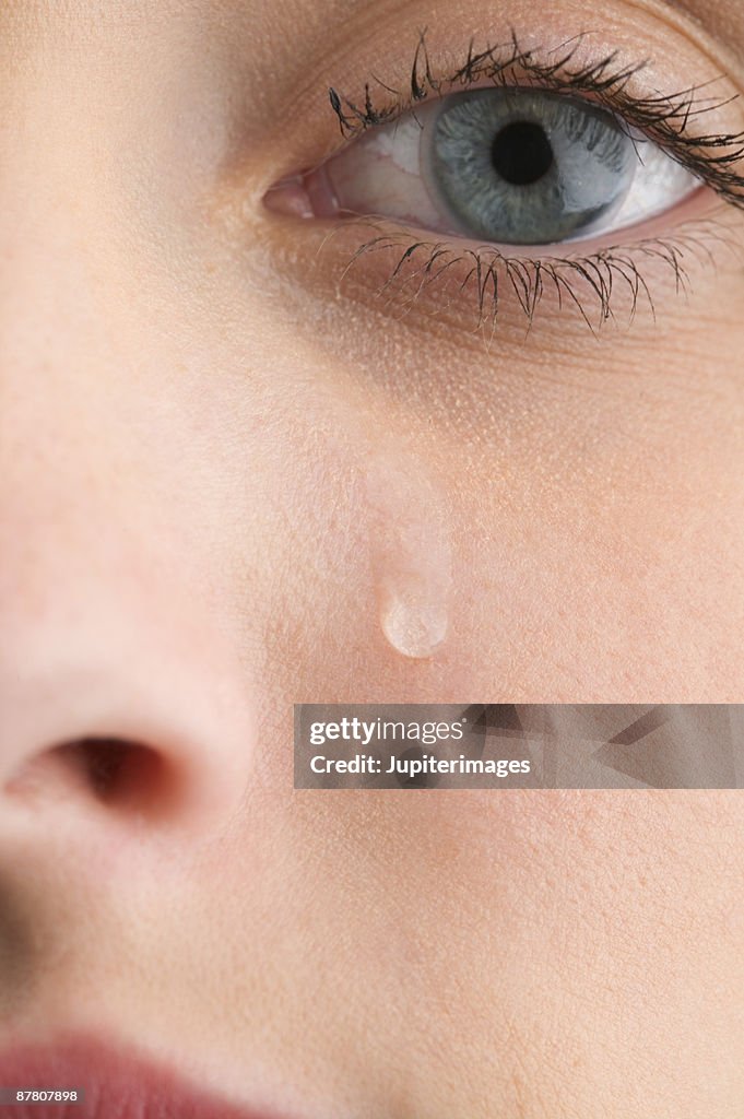 Close-up of woman's face with tear